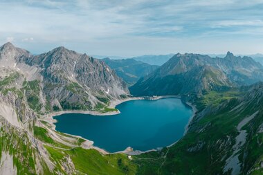 Herzförmiger See umgeben von einer malerischen Bergkulisse von oben fotografiert | © Golm Silvretta Lünersee Tourismus GmbH, Mathaeus Gartner